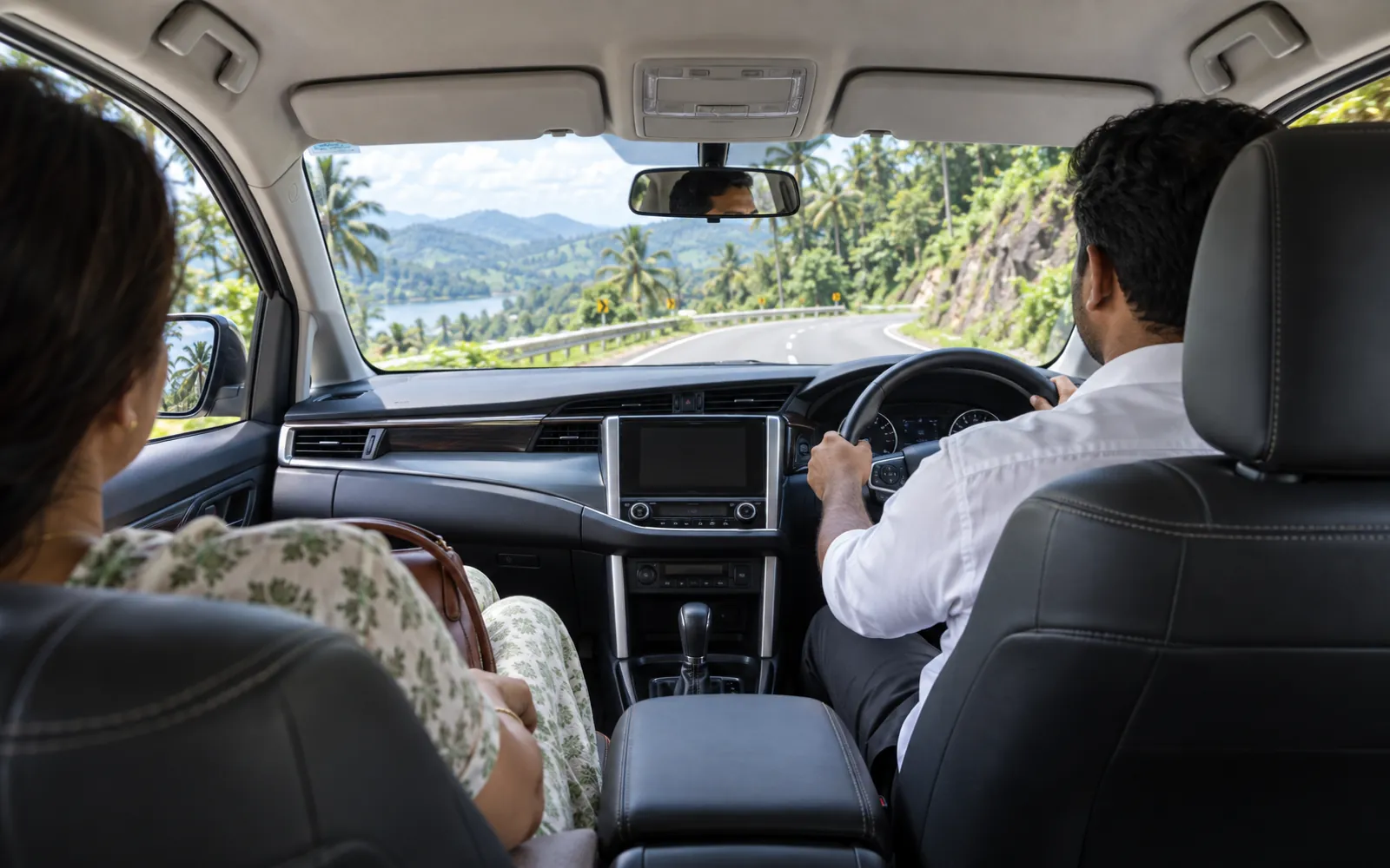 The back seat of a Mango Cabs chauffeur-driven car on a Kerala road