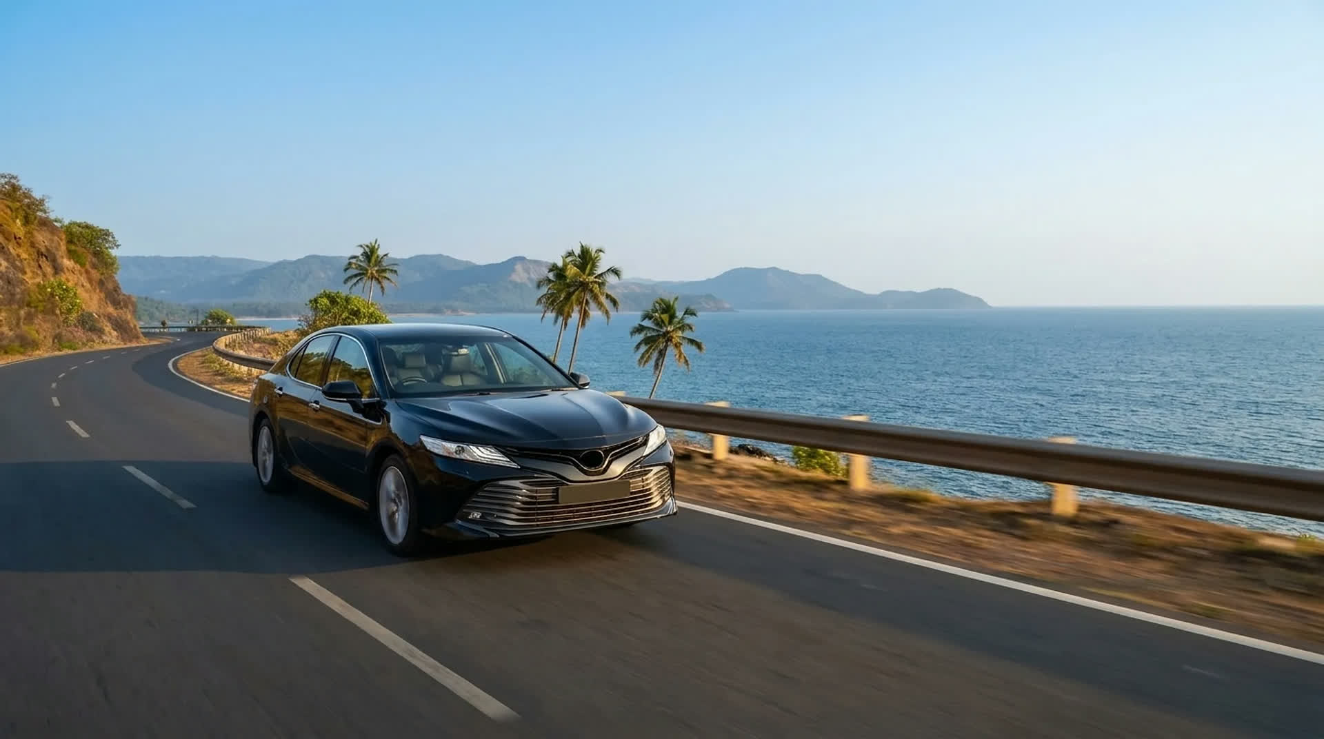 A self-drive rental sedan on a coastal Kerala highway, palms and the Arabian Sea alongside